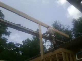 Carpenter setting a ridge beam over a new addition frame — Ice Dam Removal by Roofing Brothers in Seaboard