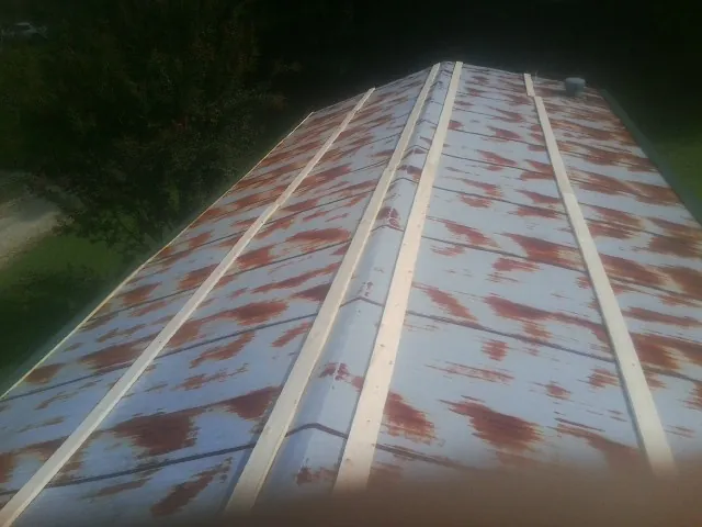 Rusted metal roof panels with new wood purlins before replacement — Storm Damage Roof Repair in Seaboard by Roofing Brothers