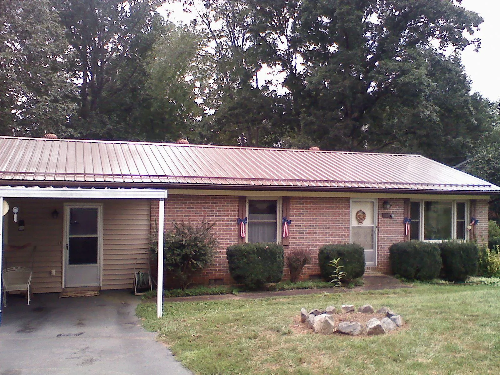 Bronze metal roof and carport on a brick ranch home — Roof Repair work by our crew in Seaboard